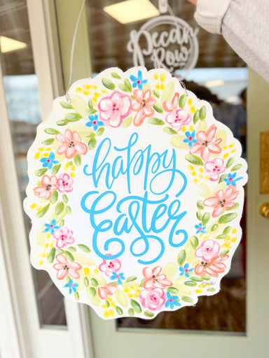 Decorative sign with 'Happy Easter' text and floral design on a door.