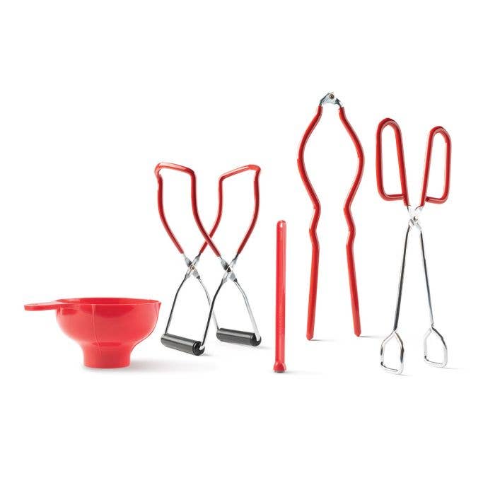 Set of red kitchen tools including a funnel, tongs, and ladle on a white background
