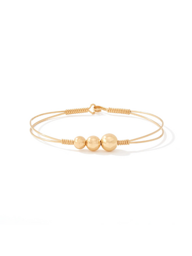 Gold bracelet with three beads on a white background