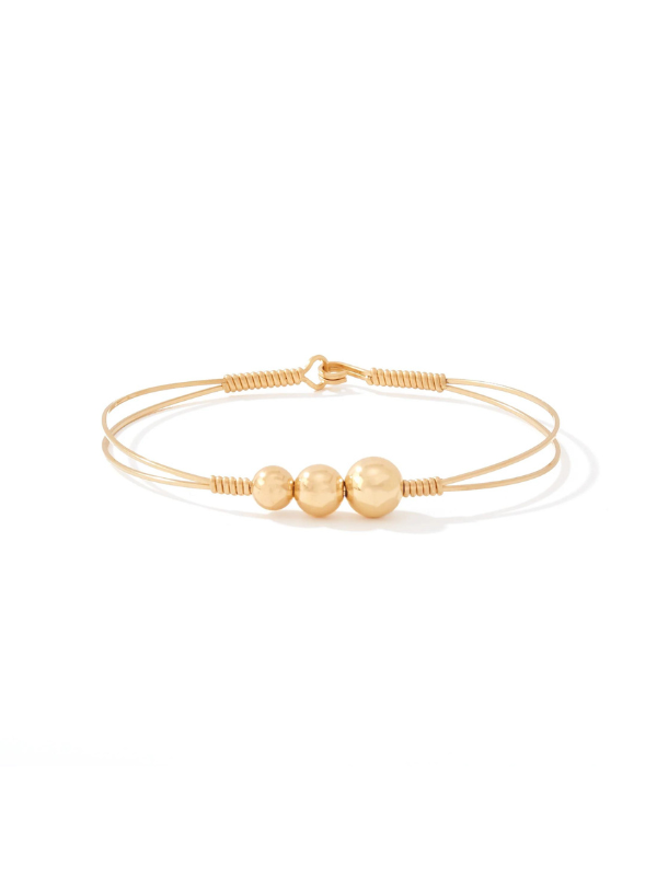 Gold bracelet with three beads on a white background