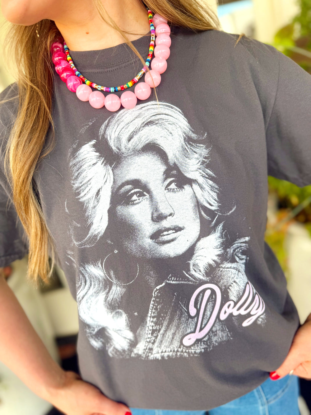  This charcoal graphic tee features a bold black-and-white Dolly Parton portrait with a soft pink Dolly signature for the perfect pop of color. 