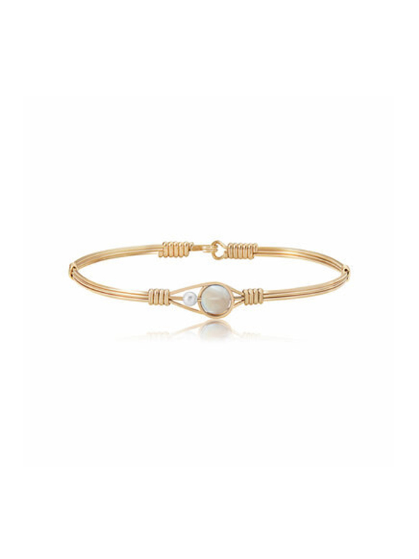 Gold bracelet with a central pearl on a white background