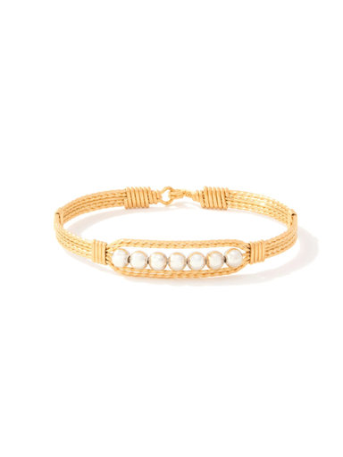 Gold bracelet with pearl-like beads on a white background