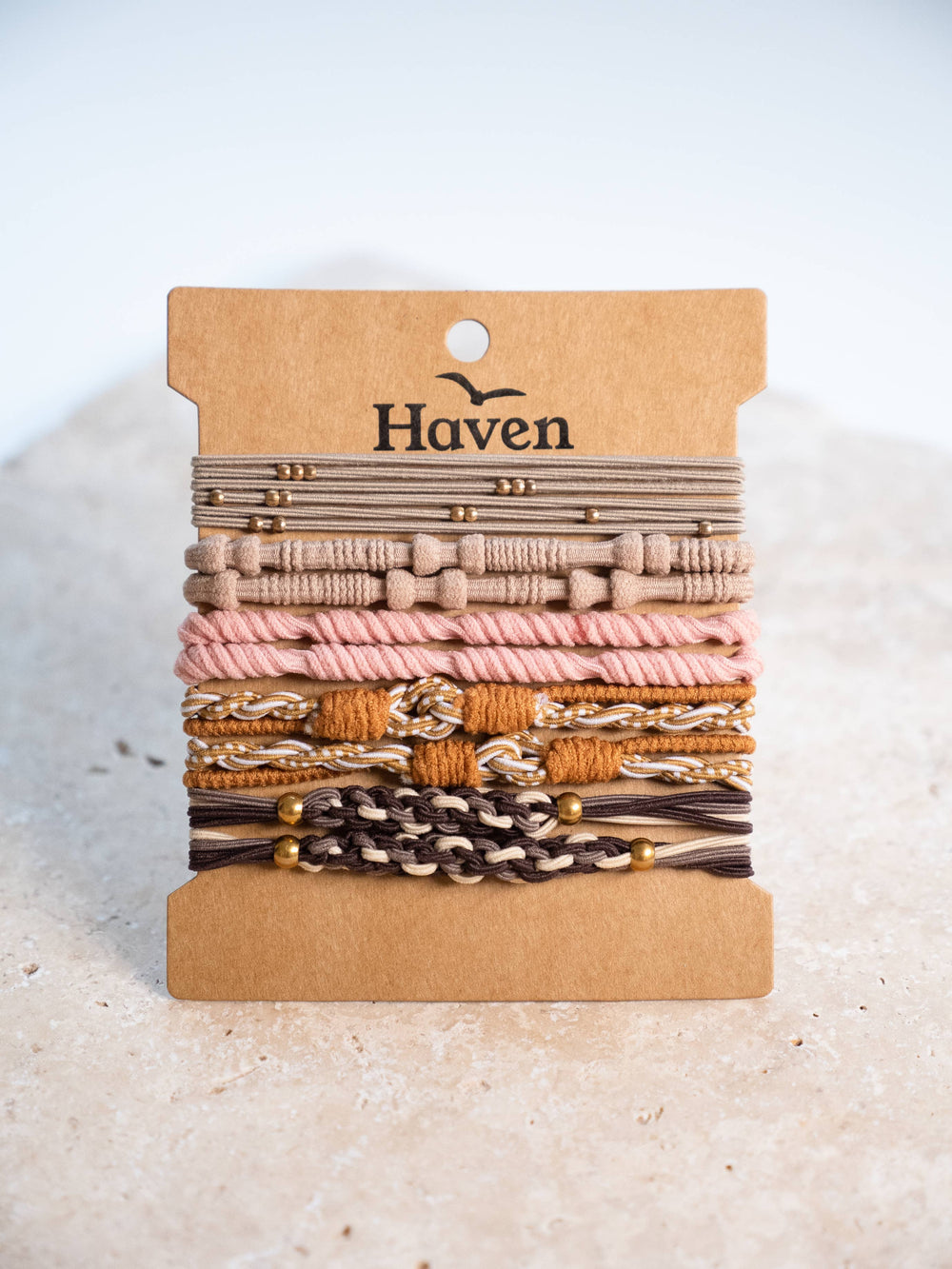 Set of bracelets/ hair ties on a cardboard holder with 'Haven' branding