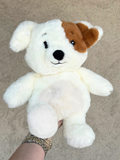 A white plush puppy toy with brown ears and a brown patch on its forehead