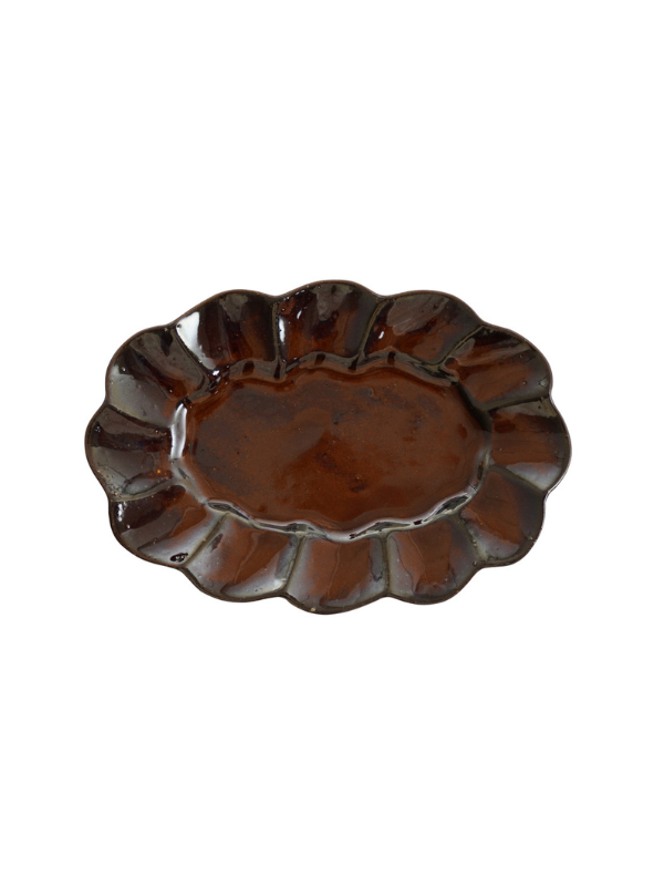 A dark brown scalloped ceramic plate with a glossy finish