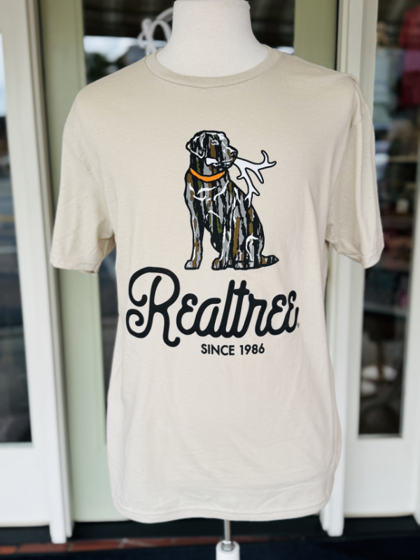 camo dog with a shed in mouth on tan tee