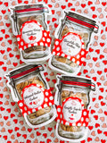 Four packages of cookies with red and white labels on a heart-patterned background