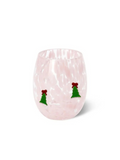 A light pink stemless wine glass with a textured, hammered finish, decorated with two small green Christmas tree ornaments with red bows near the lower front, set against a plain white background.