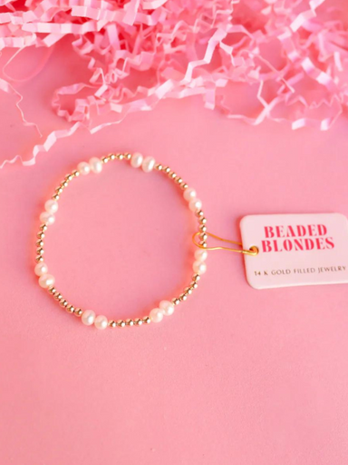 A gold beaded bracelet with freshwater pearl accents