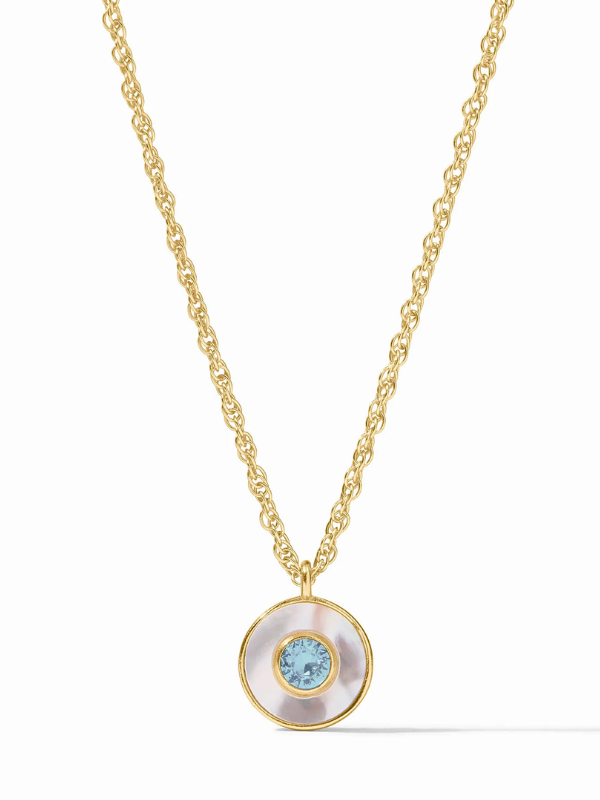 Gold necklace with a circular pendant featuring a blue gemstone on a white background