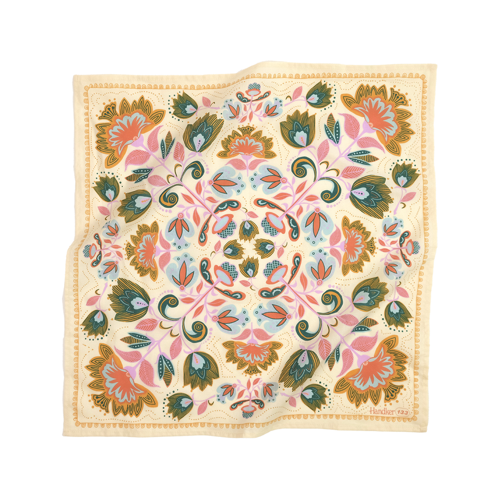 A cream-colored bandana with a floral pattern featuring teal, turquoise, orchid purple, canary yellow, and orange accents.