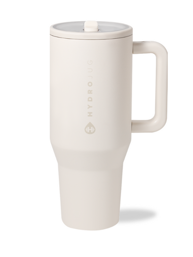 A cream-colored HydroJug Traveler 40oz tumbler with a handle and flip straw lid.