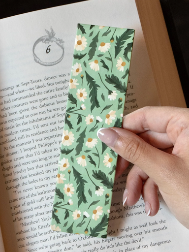 Floral bookmark held over a book