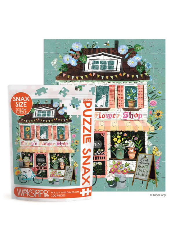 A children's jigsaw puzzle and its retail box shown on a white background. The puzzle features a whimsical illustration of a flower shop with flowers, bicycles, cats, and a turquoise sky.