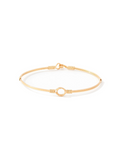 A delicate gold bangle bracelet with a central open circle and textured wrap details, displayed on a clean white background.