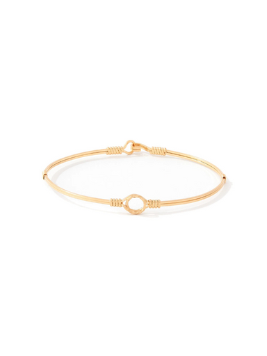 A delicate gold bangle bracelet with a central open circle and textured wrap details, displayed on a clean white background.
