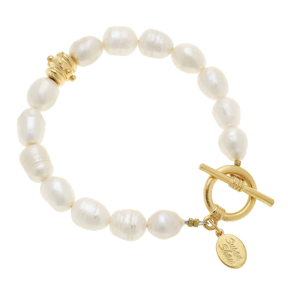Pearl bracelet with gold clasp and tag on a white background