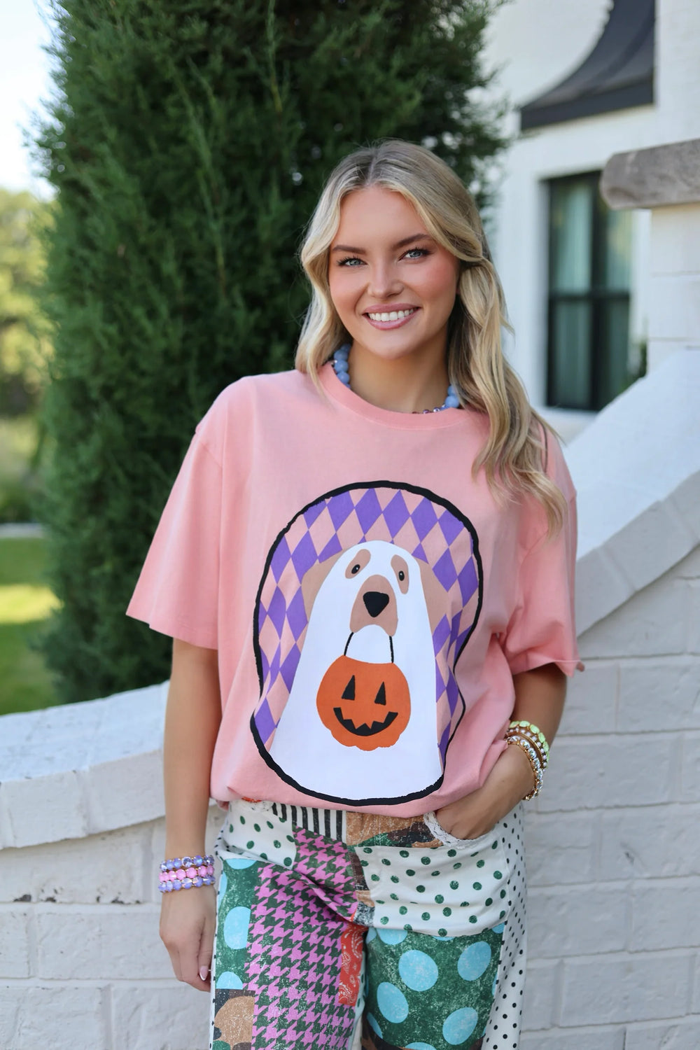 Peach colored tee with a ghost puppy holding a trick or treat basket 