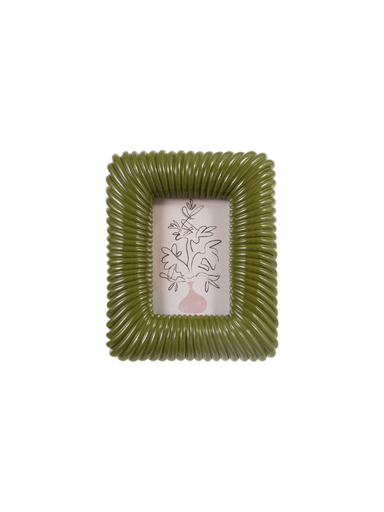 An olive green ribbed square picture frame with a white insert featuring a delicate black floral line drawing and a small pink vase at the bottom.