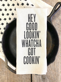 Kitchen towel with text over a cast iron skillet on a wooden surface