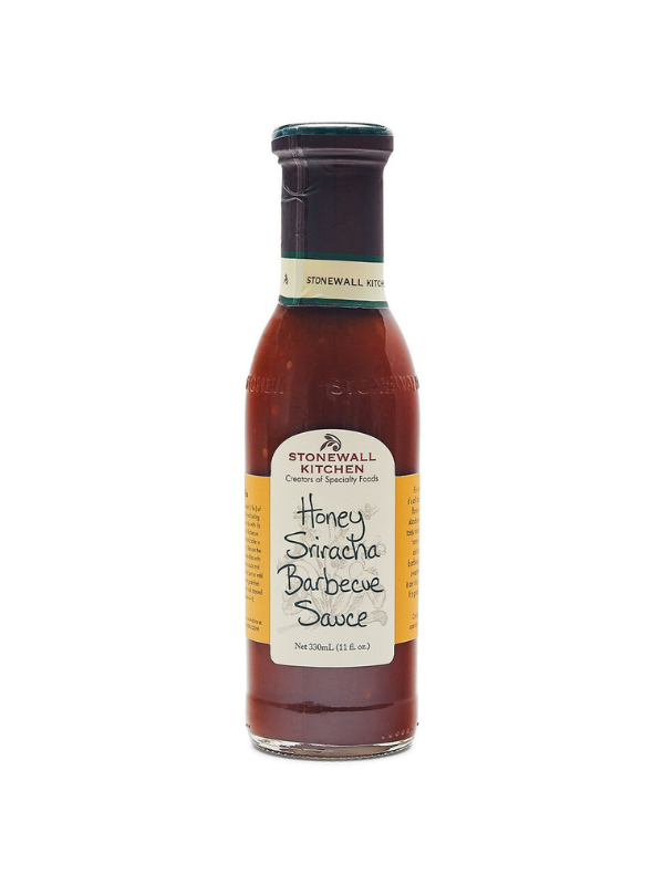 A bottle of Honey Sriracha Barbecue Sauce by Stonewall Kitchen with a label showing the product name and the phrase 'True Grill Masters Know'. The sauce appears dark red and is packaged in a clear glass bottle.