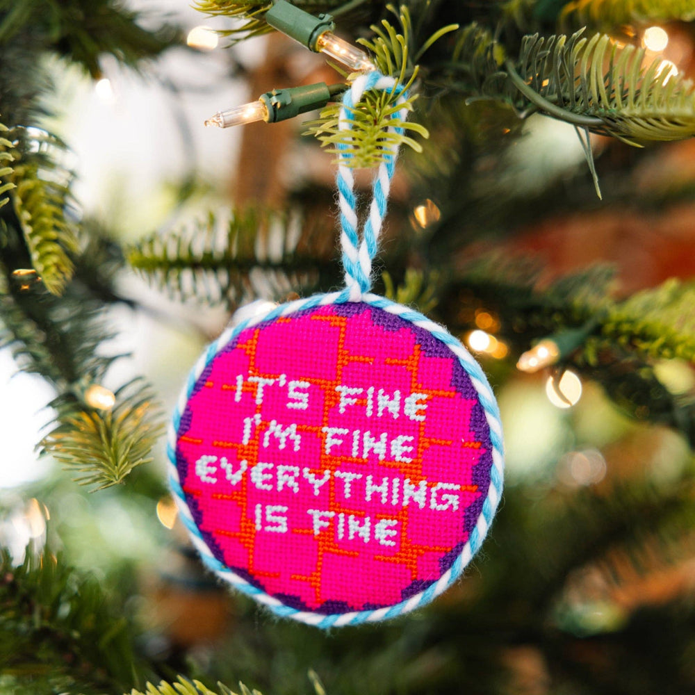 Circular ornament with 'It's fine, I'm fine, everything is fine' text on a Christmas tree.