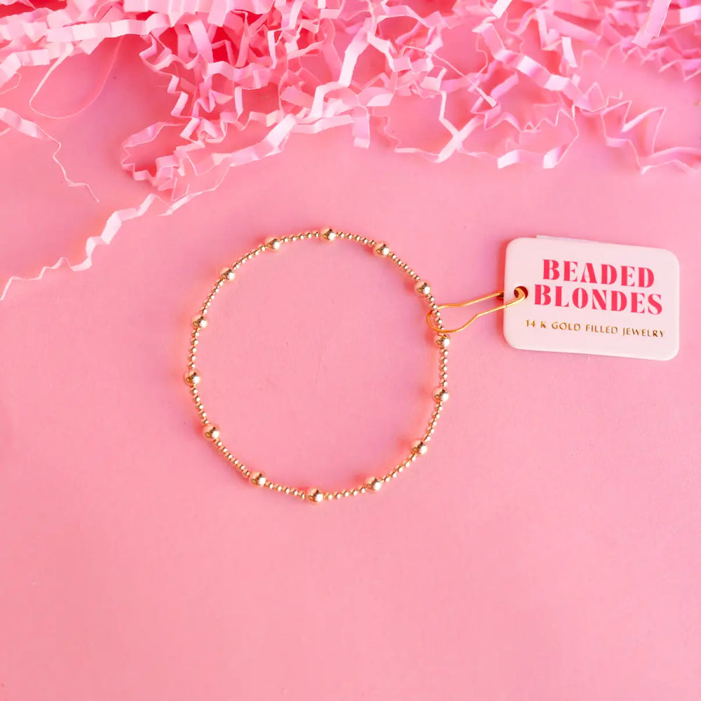 A gold-filled bracelet with a mix of smaller and larger beads