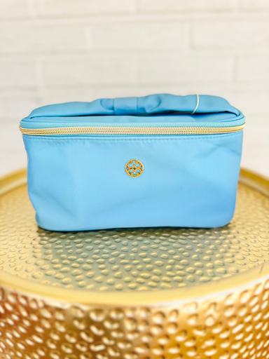 blue makeup bag with floral pattern on the inside and bow handle
