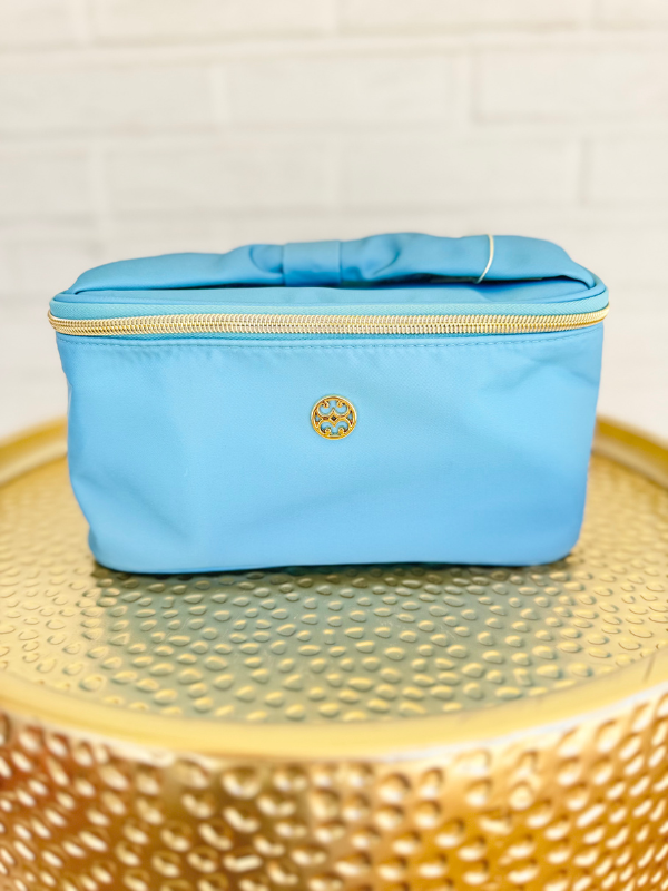 blue makeup bag with floral pattern on the inside and bow handle