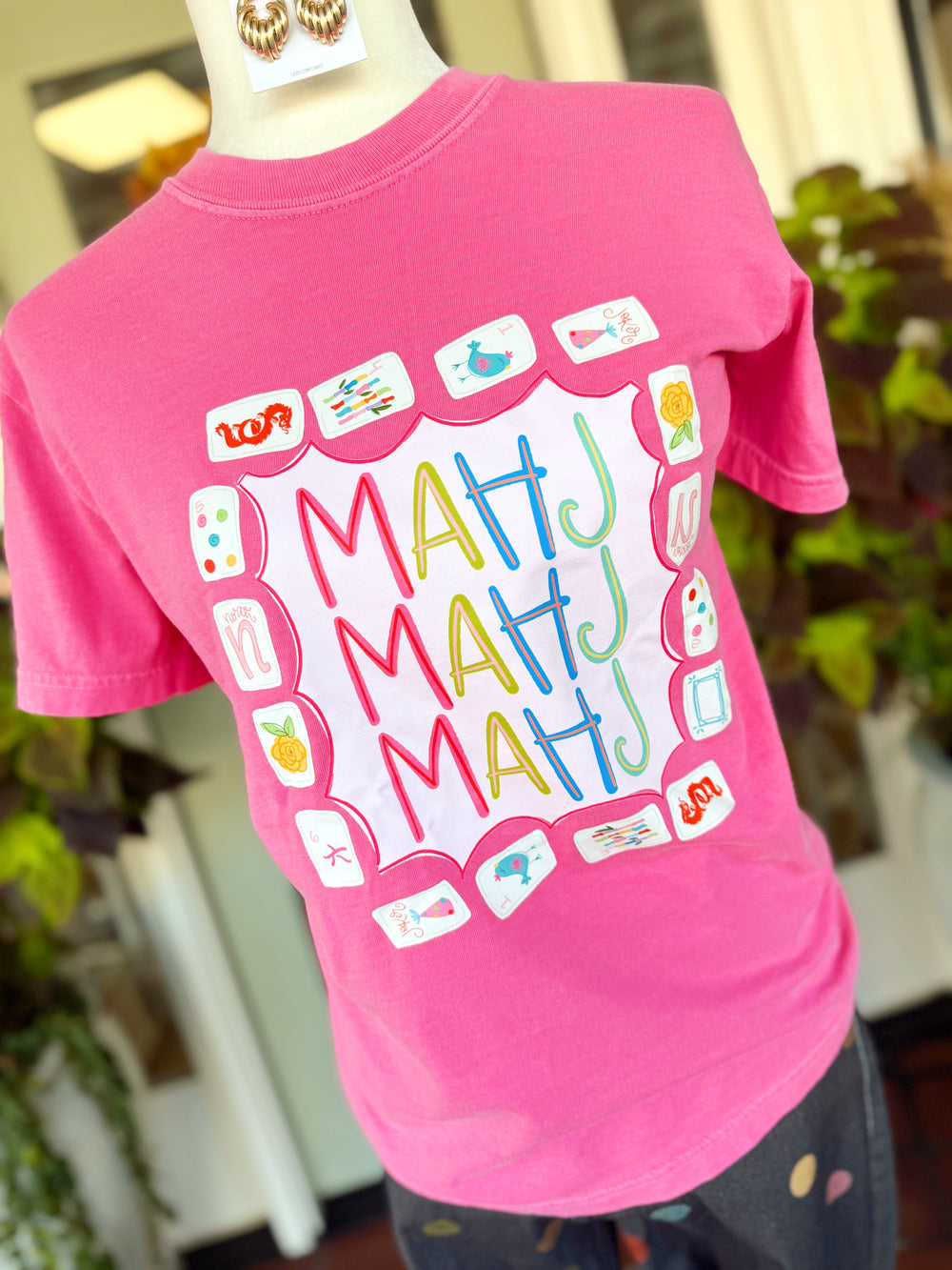 Printed on a vibrant Crunchberry Comfort Colors® tee, this playful design features colorful "MAHJ" lettering surrounded by charming Mahjong tiles for a fun look