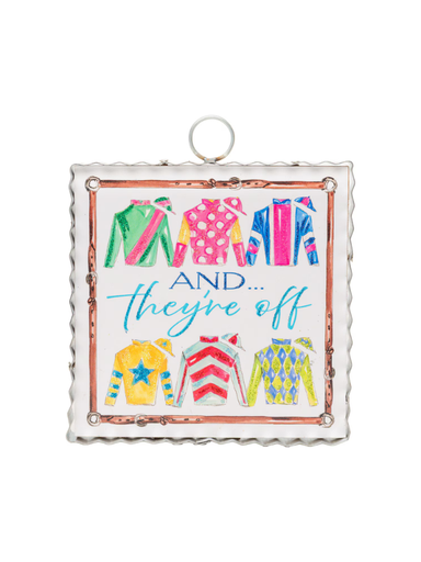 Decorative sign with colorful horse racing jackets with "And They're Off" text