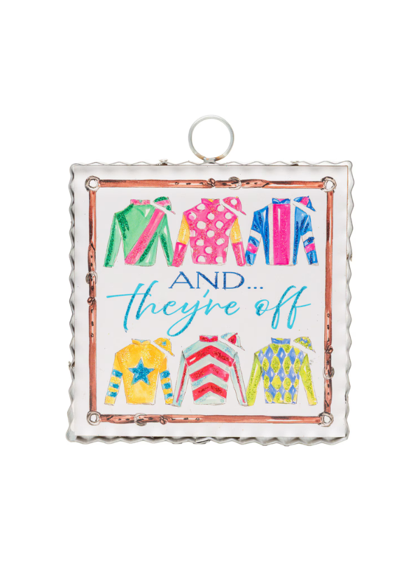 Decorative sign with colorful horse racing jackets with "And They're Off" text