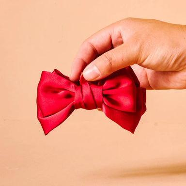 This statement claw clip features an oversized red satin bow that instantly adds a polished, feminine touch to any look.
