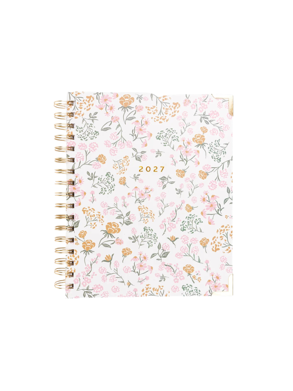 A 2027 spiral-bound planner with a delicate pink, orange, and green floral pattern on a white cover, featuring gold-toned metal spiral binding.