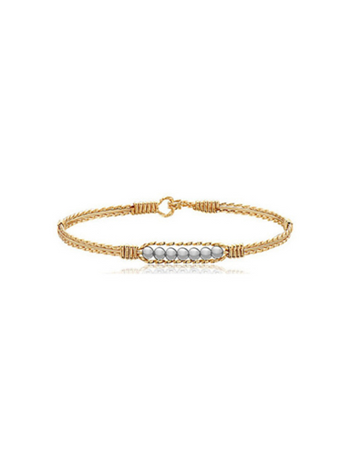 Gold bracelet with pearl beads on a white background