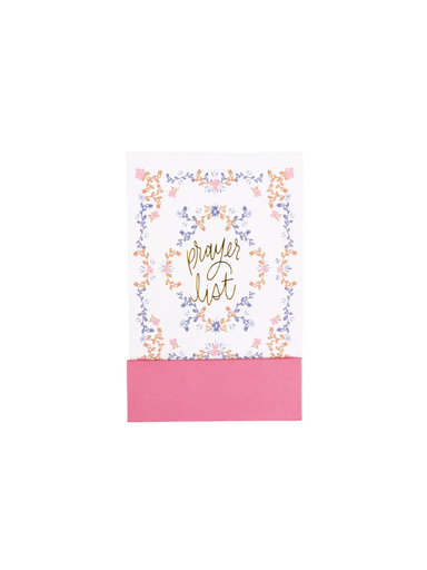 A small white card or notebook with a pink paper band at the bottom, decorated with a delicate floral border in pastel pink, blue, and orange around the words 'prayer list' in gold script.