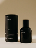 Black cologne bottle and cylindrical container on a beige background