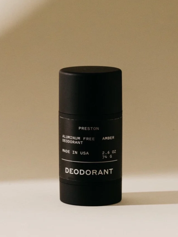 Black deodorant stick with text on a beige background