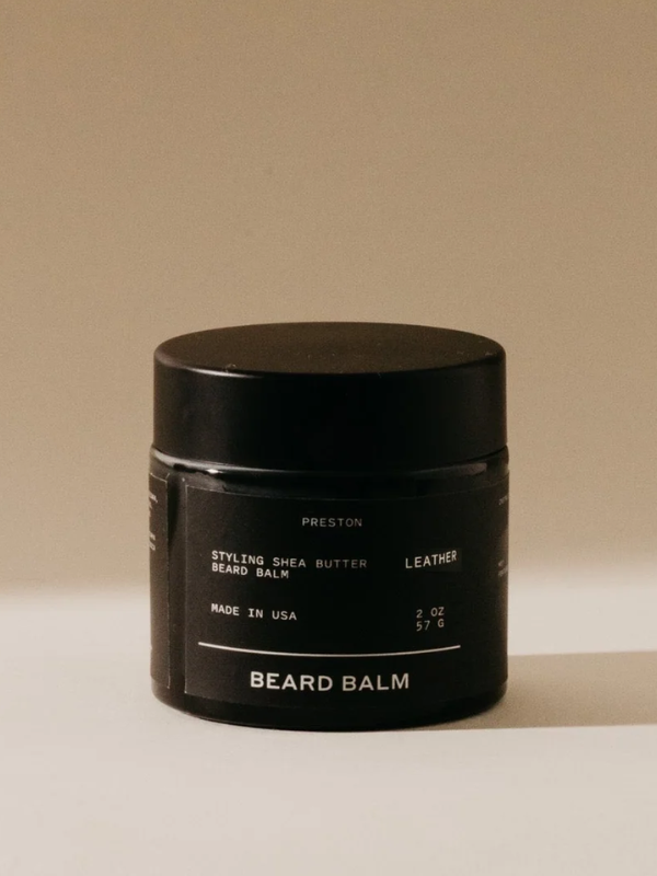 Black jar of beard balm on a beige background