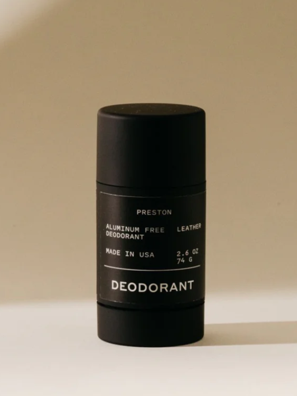 Black deodorant stick with branding on a beige background