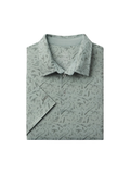 Sage green polo with guns, ducks antlers and dogs printed on it 