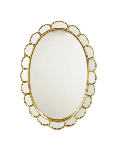 An oval wall mirror with a decorative gold scalloped metal frame