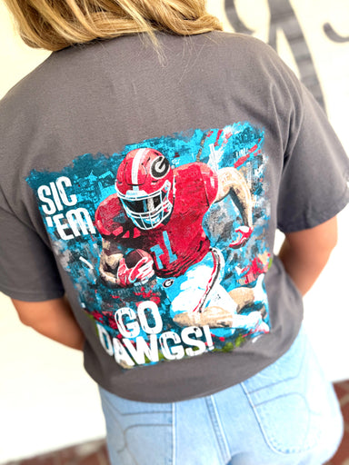 A dark gray t-shirt with a large graphic print of a football player in a red uniform and the text 'SIC 'EM GO DAWGS!'.