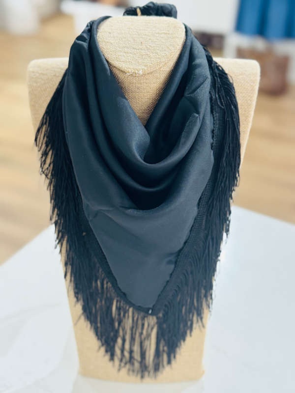 A black scarf with long fringe trim
