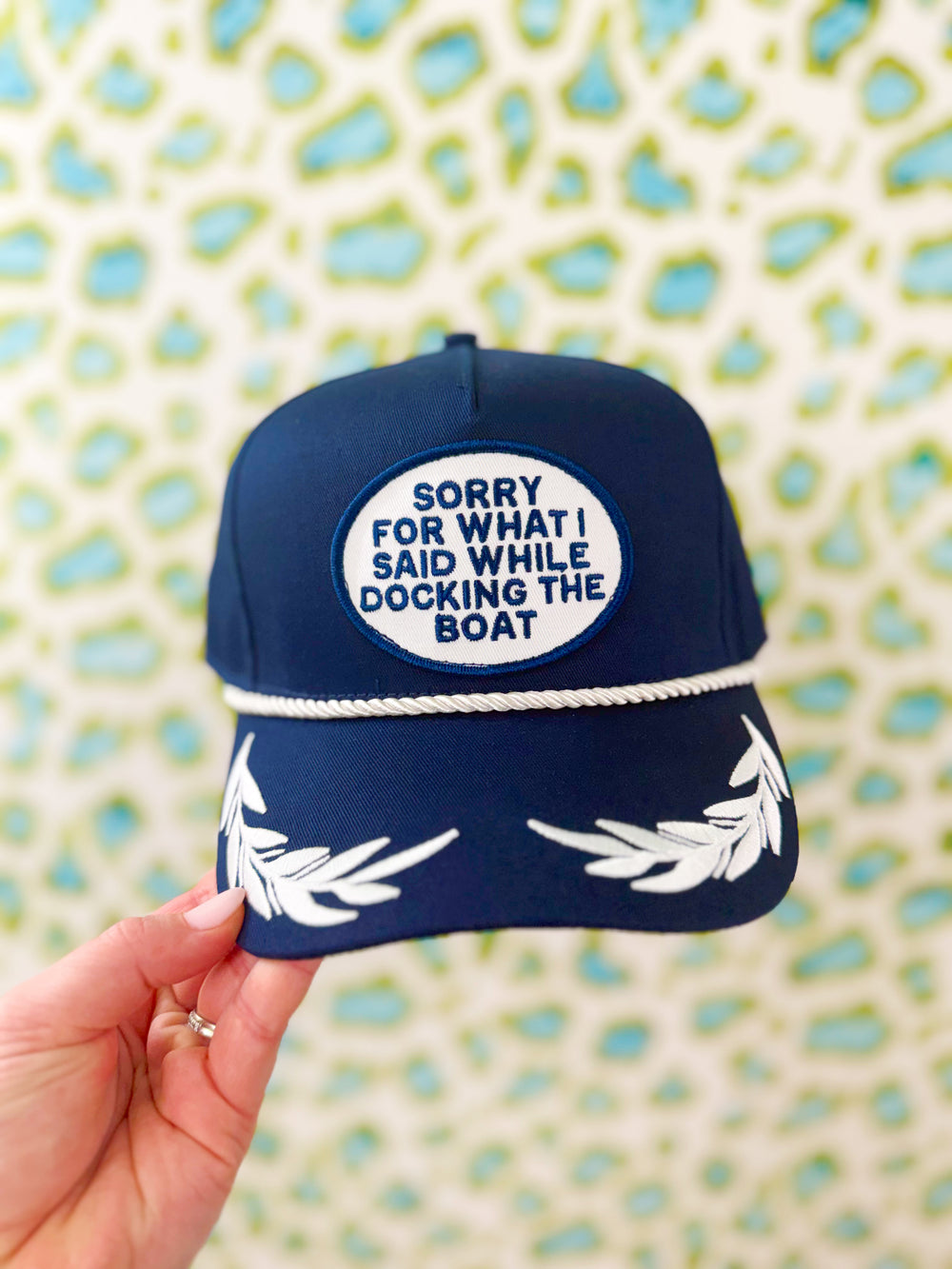 Navy blue rope cap with white text and patch design 