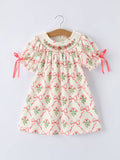Children's dress with floral and bow pattern.