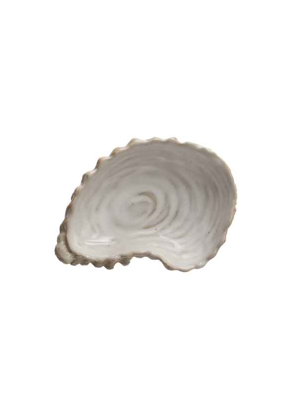 A single irregular shell-shaped ceramic dish or tray with a scalloped rim and concentric ring texture, shown on a plain white background.
