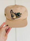 flying duck with a hat and chain on a tan hat