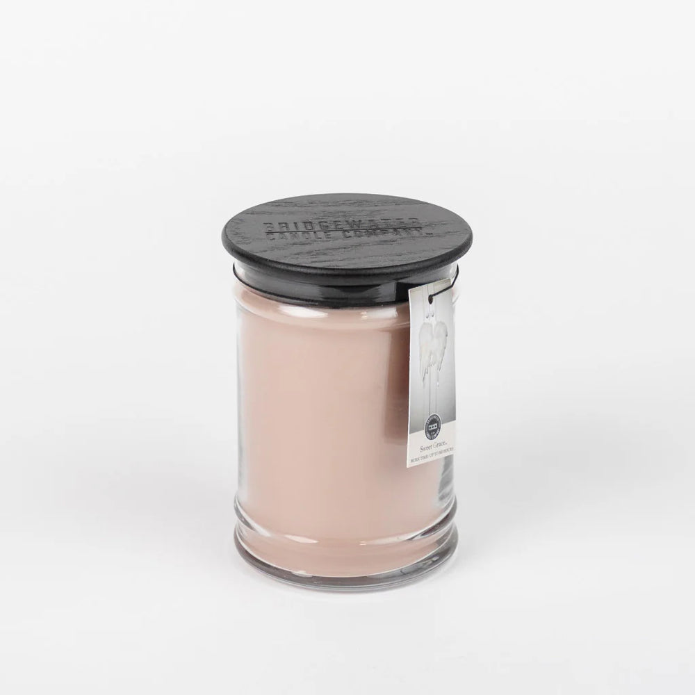 A Bridgewater candle in an clear glass jar with a black wooden lid.